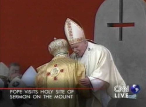 Obrácený kříž na papežově křesle